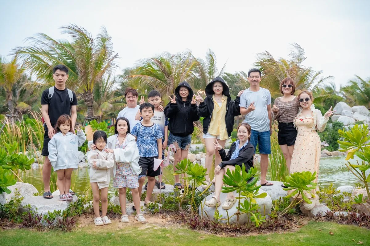 Đại gia đ&igrave;nh đa thế hệ chụp ảnh b&ecirc;n hồ cảnh quan xanh m&aacute;t tại CaraWorld Cam Ranh