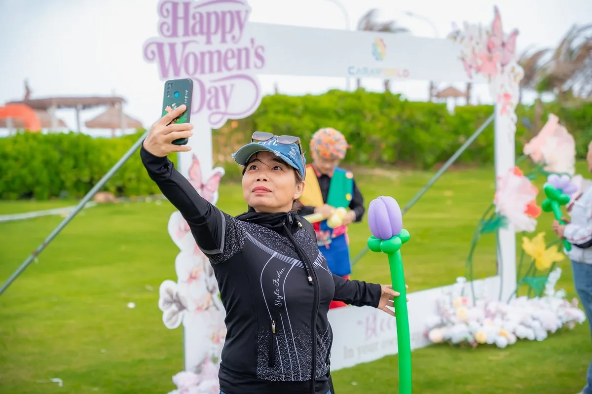Phụ nữ selfie check-in tại photo frame Happy Women Day trang tr&iacute; hoa bướm CaraWorld
