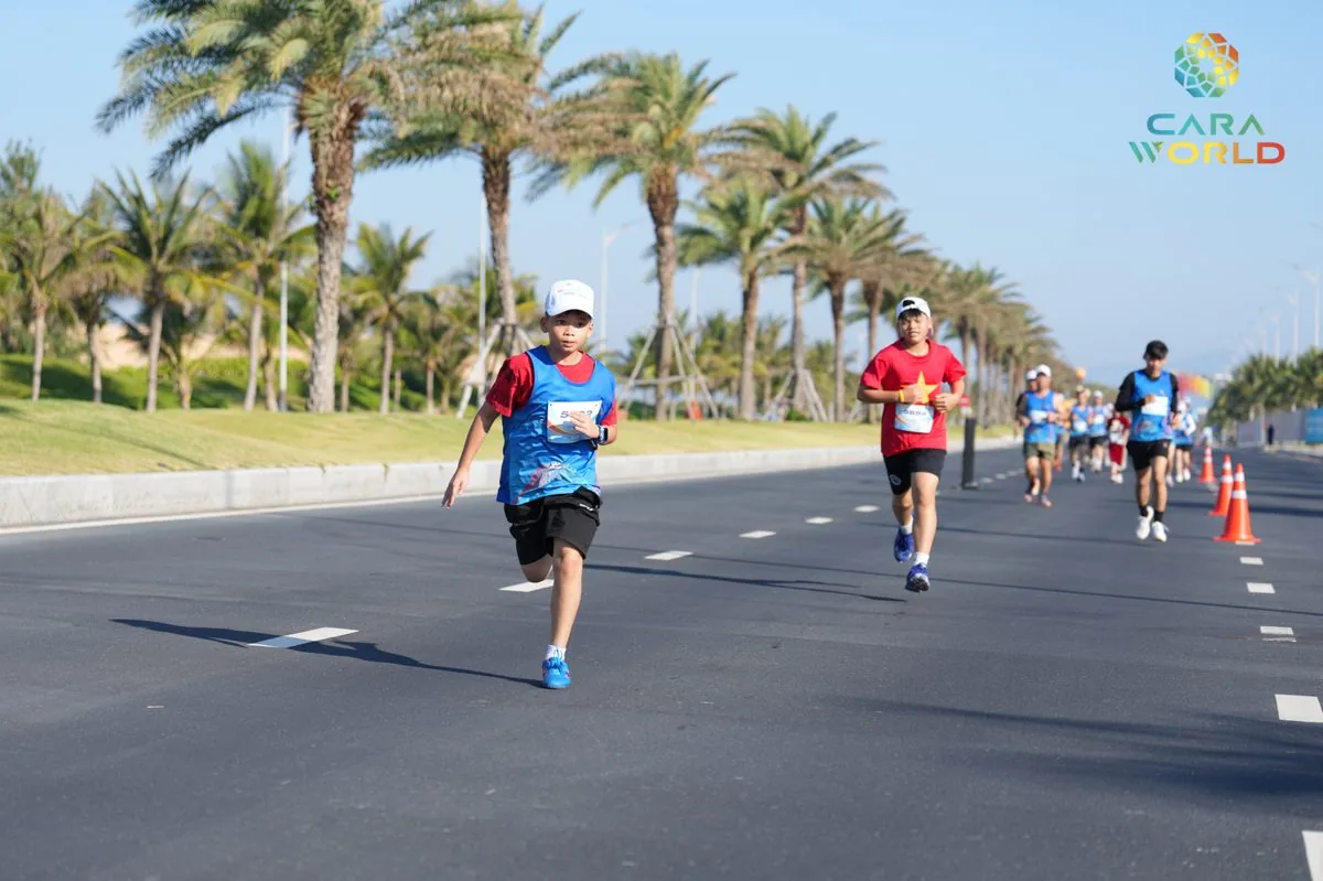 Vận động vi&ecirc;n nh&iacute; v&agrave; người lớn chạy tr&ecirc;n đại lộ h&agrave;ng cọ dừa ven biển CaraWorld Cara Run 2026